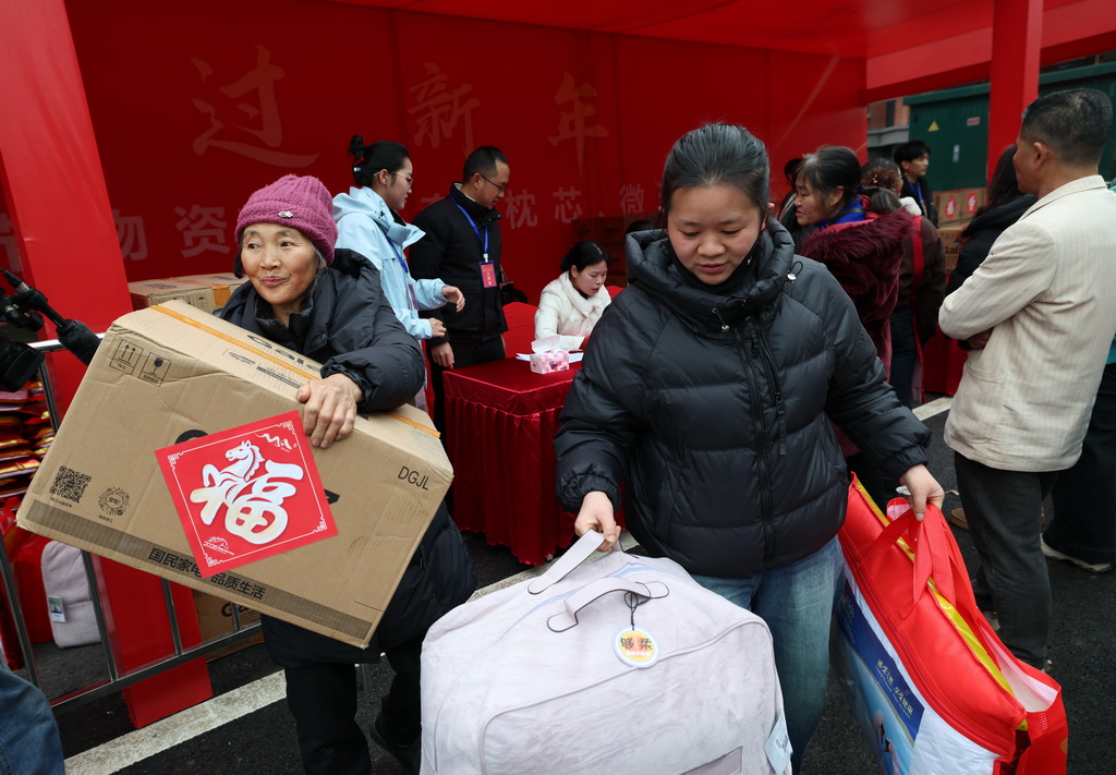1月31日，在四川省宜宾市筠连县沐爱镇金坪村搬迁安置区，喜迁新居的受灾群众领取免费物资。