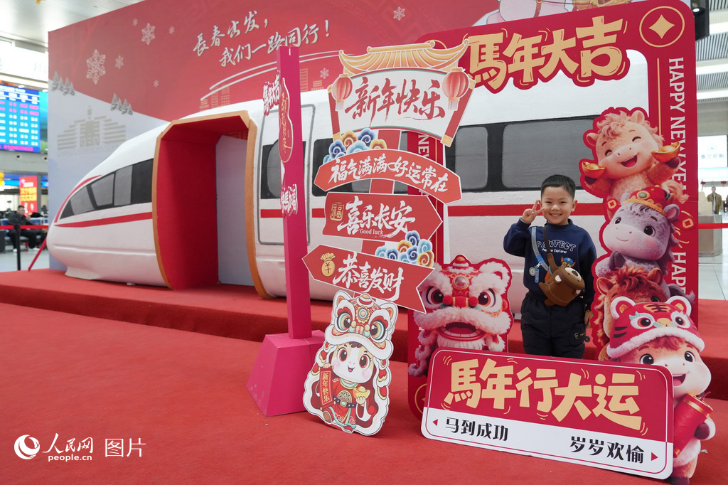 2月2日，长春火车站候车大厅内，马年新春主题装饰格外喜庆。一名小朋友在“马年大吉”等新春祝福语前驻足留影。人民网记者 李洋摄