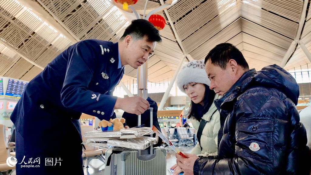 2月2日，北京朝阳站民警正将印有安全知识、反诈电话的宣传品、宣传册发放给旅客，让旅客把反诈知识带回家，传递给家人。人民网记者 李世奇摄