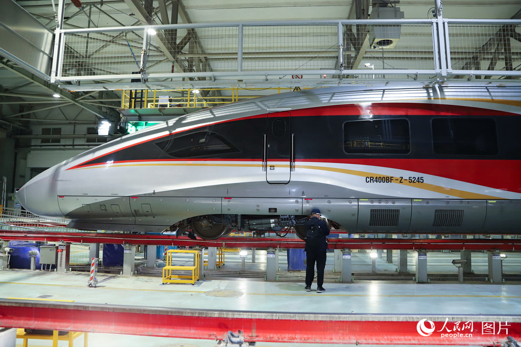 1月30日，兰州车辆段动车组机械师检查动车组列车走行部。人民网记者 焦隆摄