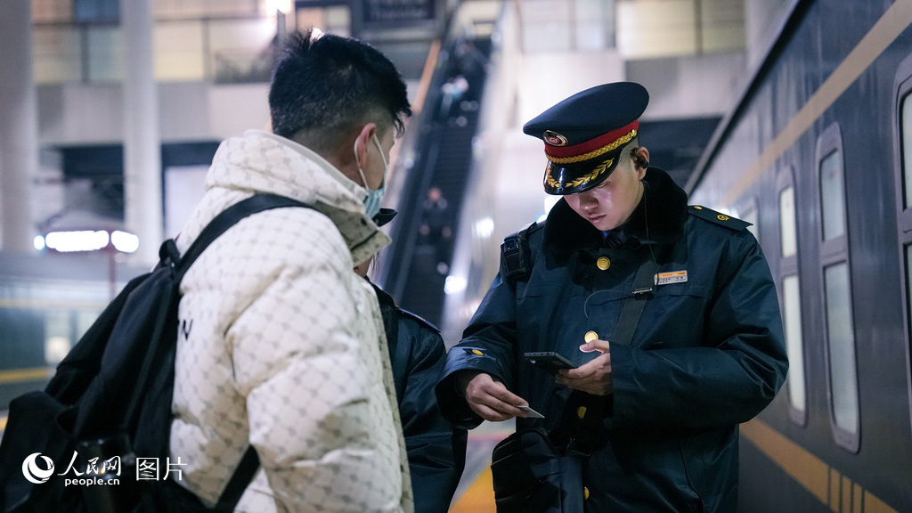 2月2日，银川火车站，K1297次列车的乘务员正在车厢门口核验席位，迎接旅客乘车。人民网记者 梁宏鑫摄