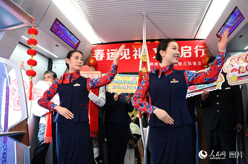 2月2日上午10点，郑州新郑机场开往开封的C2768次城际列车上，乘务员向旅客演示手语，给大家带去新年的问候。人民网记者王玉兴摄