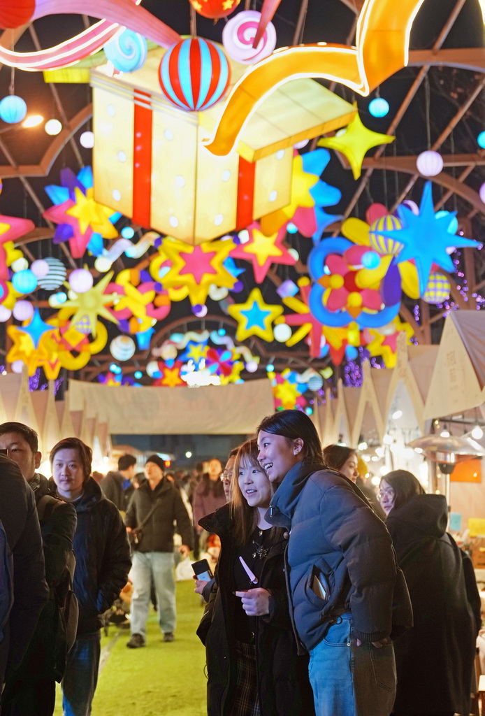 2月1日晚，游客在外滩枫径年味集市休闲游览。