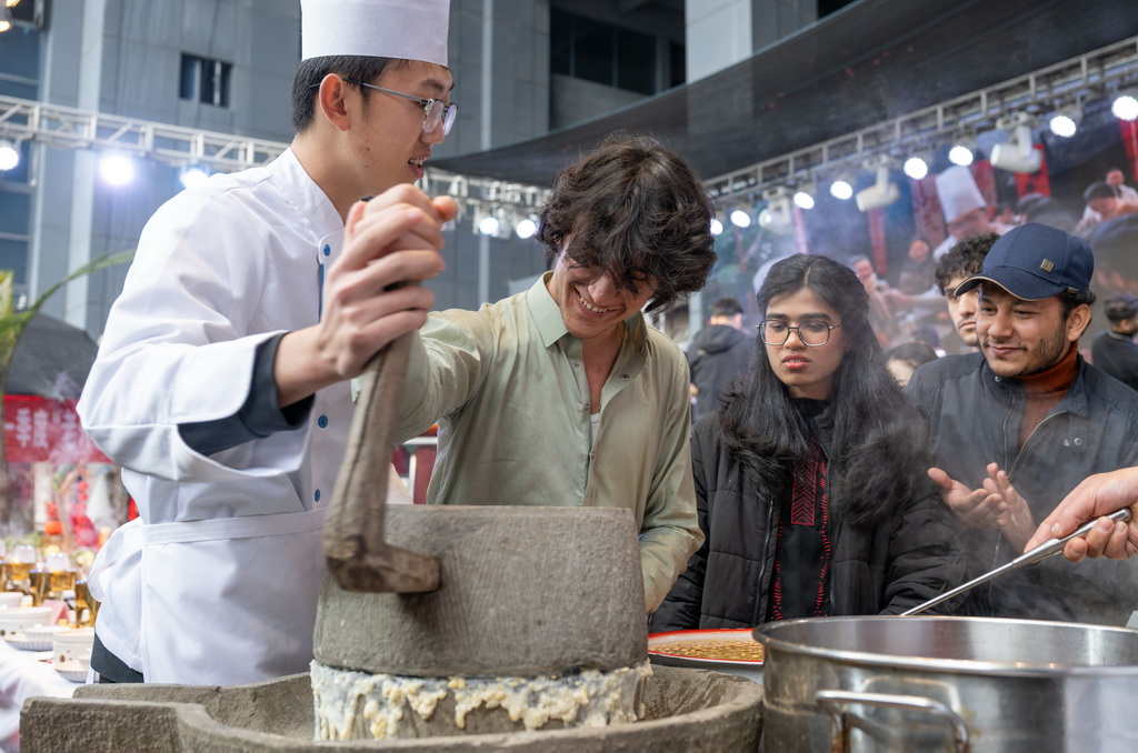 2月3日，在重庆市巴南区，留学生现场体验磨豆浆。