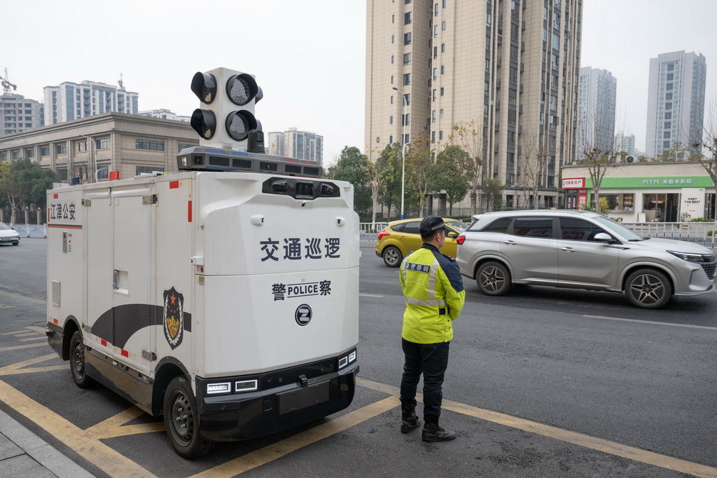 2月4日,“AI警员”(智能无人巡检装备)与重庆市江津区公安局交通管理支队警员一起巡逻。