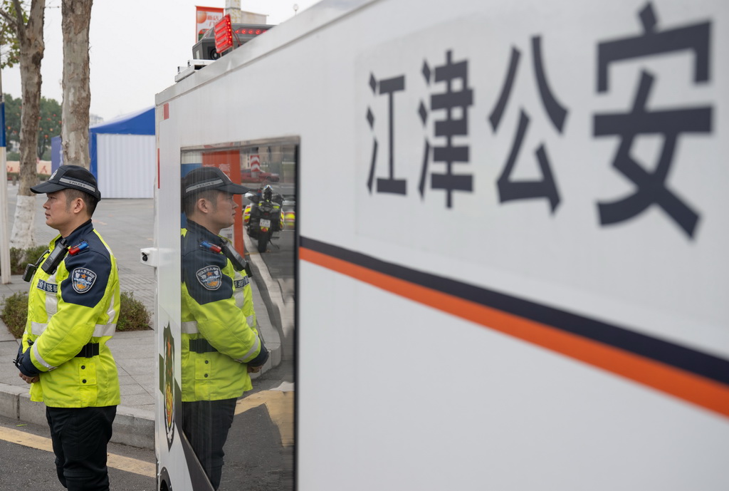 2月4日,“AI警员”(智能无人巡检装备)与重庆市江津区公安局交通管理支队警员一起巡逻。