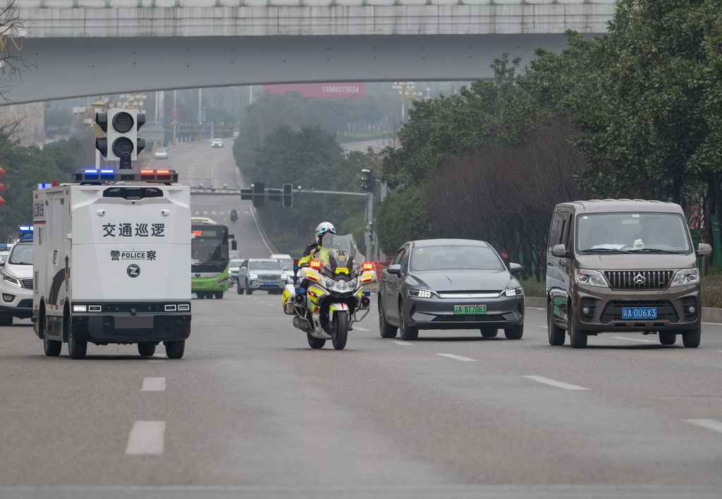 2月4日,“AI警员”(智能无人巡检装备)与重庆市江津区公安局交通管理支队警员一起巡逻。