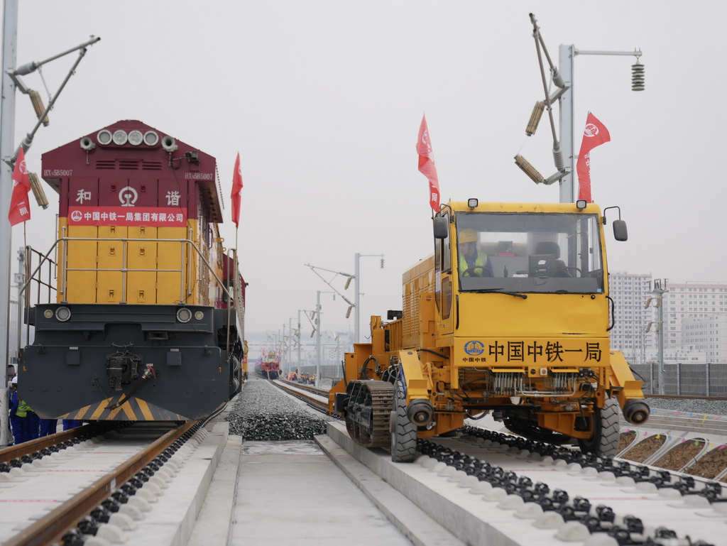 2月6日，中铁一局施工人员操作设备在西康高铁安康西站段铺设无缝钢轨。