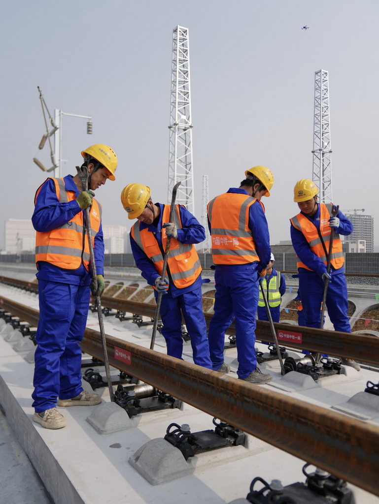 2月6日，中铁一局施工人员在西康高铁安康西站段铺轨现场作业。