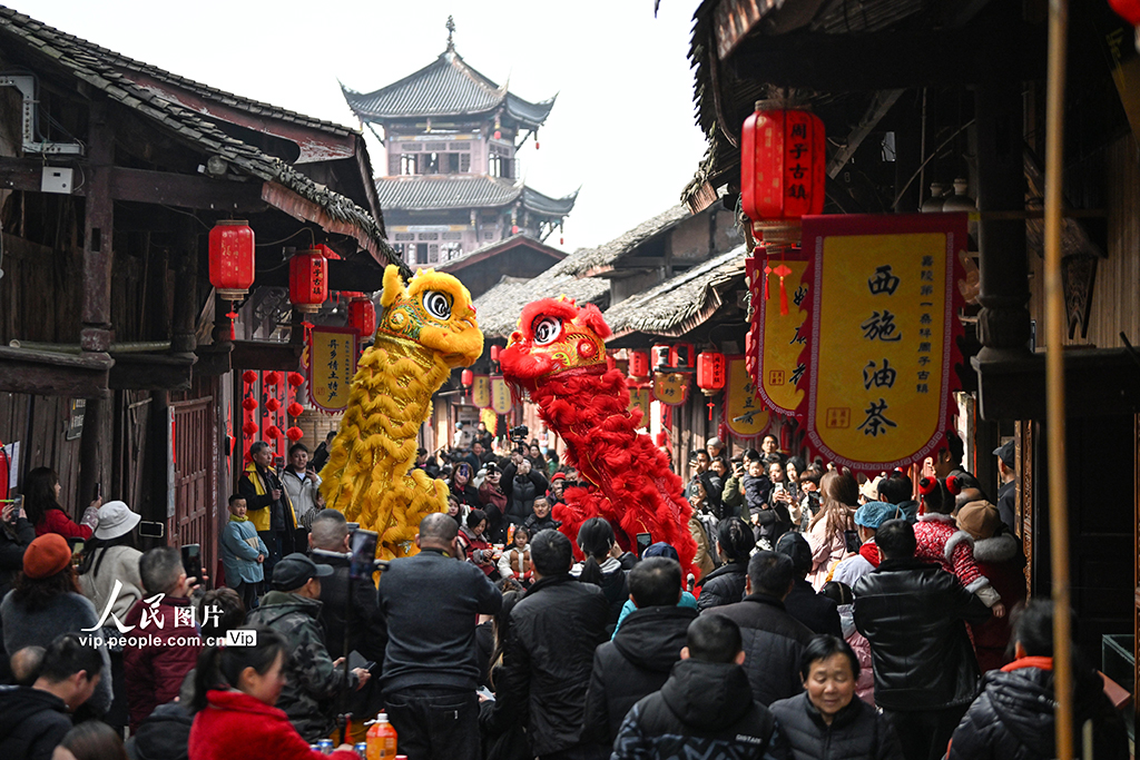 2026年2月10日，四川南充周子古镇暖意融融，返乡游子与乡亲欢聚一堂，观看舞狮表演，共迎新春。由当地居民自发组织的35桌“团年宴”热闹开席，大家品尝家乡味，畅叙邻里情。李向雨摄（人民图片网）