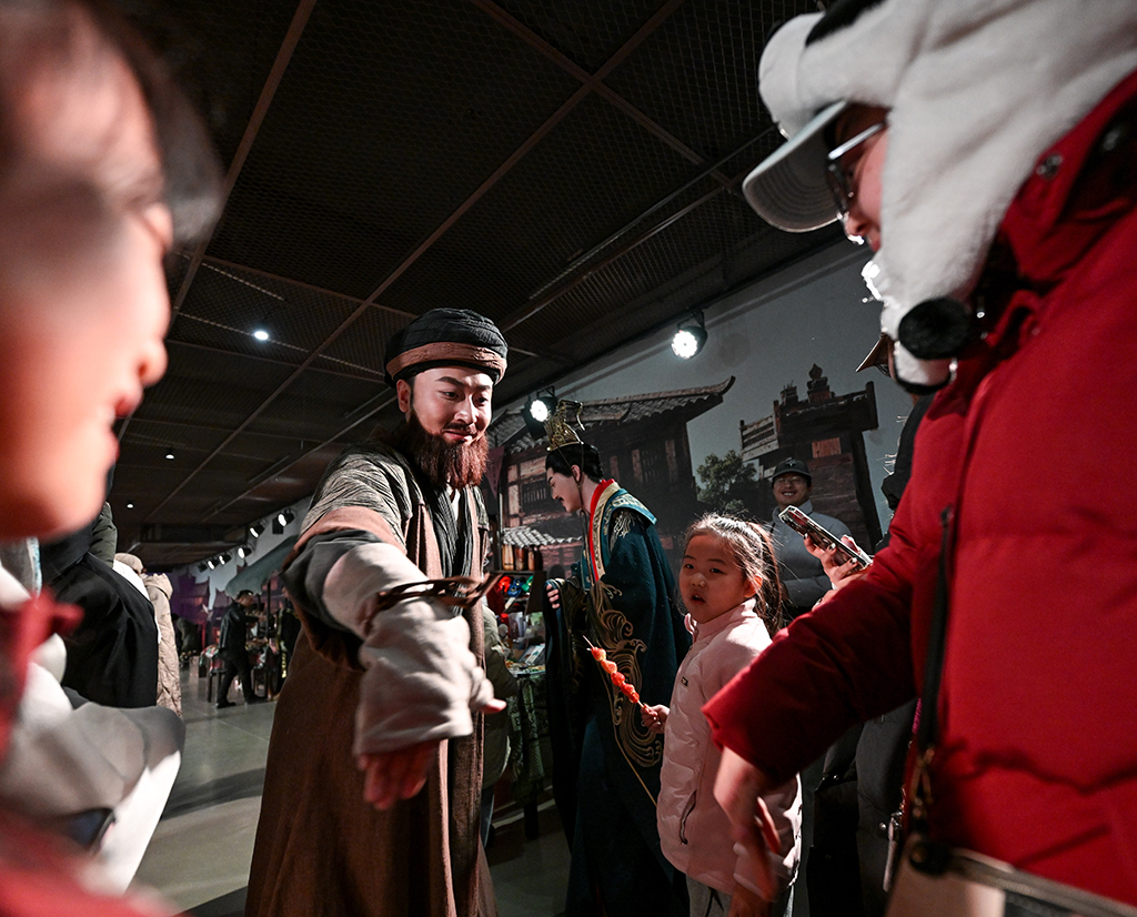 2月13日，游客在银川市西夏陵景区与一名扮演乔峰的演员（左二）互动。新华社记者 冯开华 摄