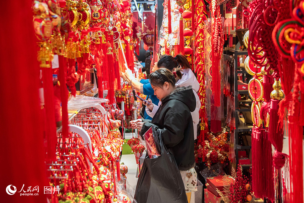 2026年2月11日，黑龙江省哈尔滨市道里区透笼轻工批发市场，市民在购买春联。人民网记者 徐成龙摄