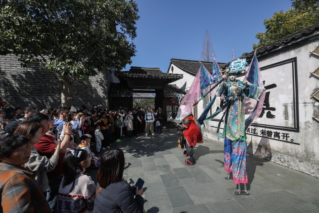 2月21日在乌镇景区内拍摄的高跷巡游表演。