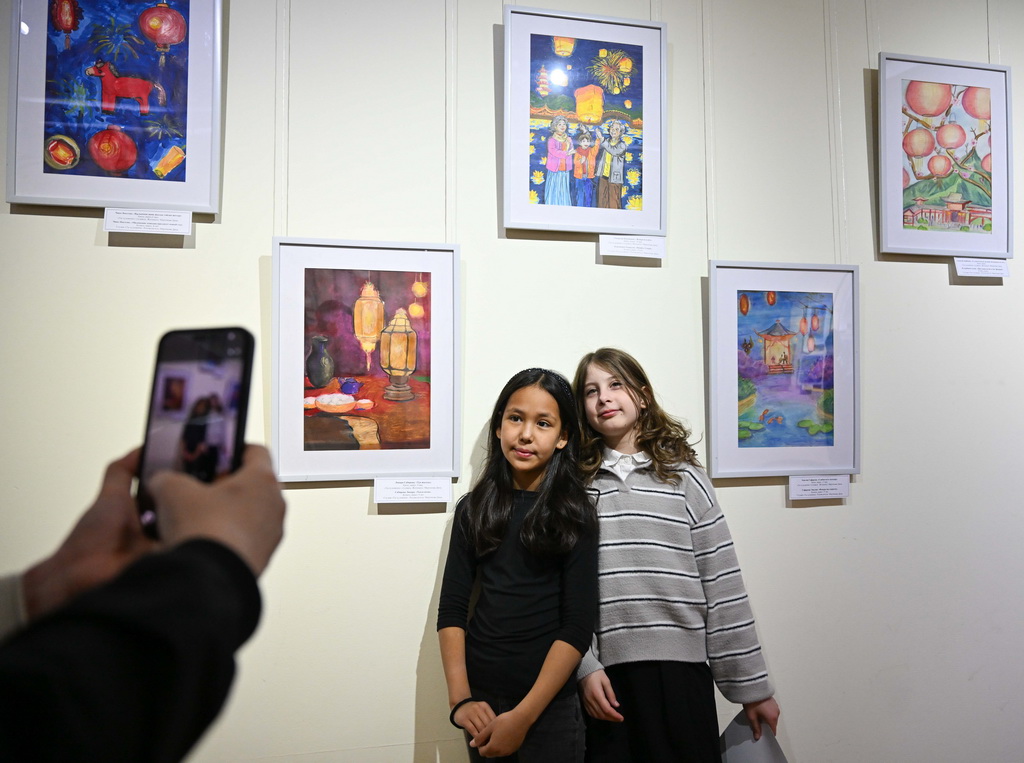 2月23日，在位于阿拉木图的哈萨克斯坦中央国家博物馆，两名女孩在画展上拍照留念。