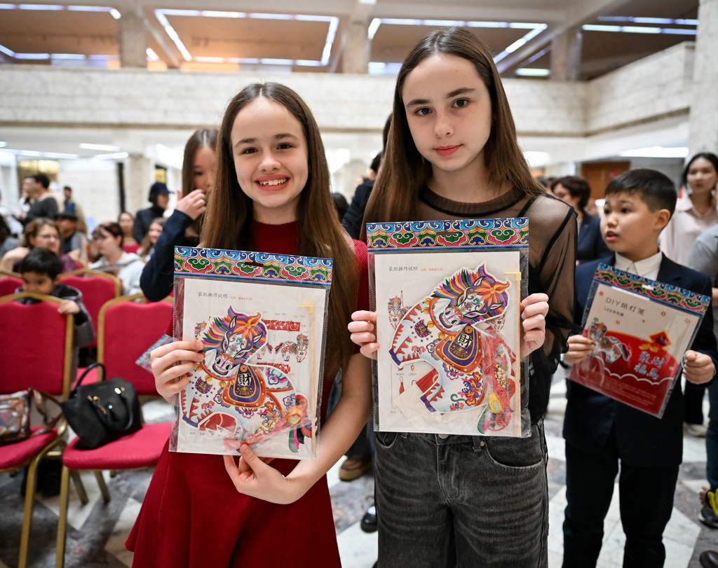 2月23日，在位于阿拉木图的哈萨克斯坦中央国家博物馆，两名女孩展示在开幕式上领取的纪念品。