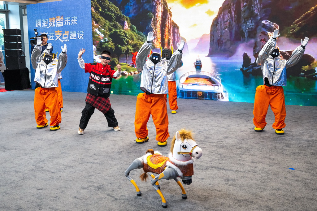 2月24日,小朋友与人形机器人在现场一起表演。