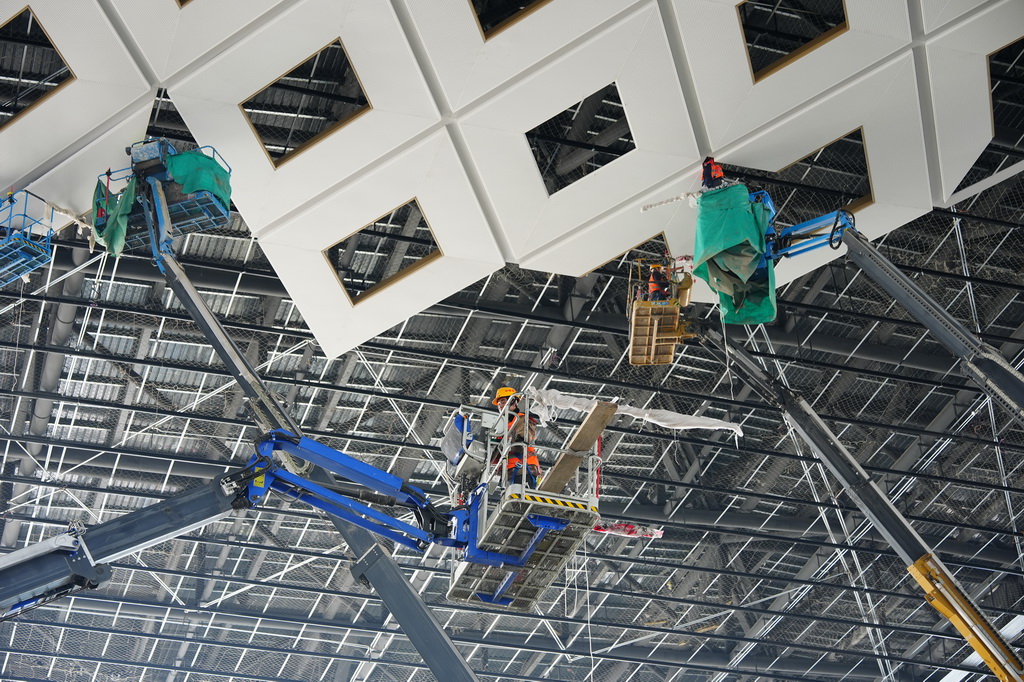 2月26日,工人在西安东站候车大厅内部进行吊顶安装。