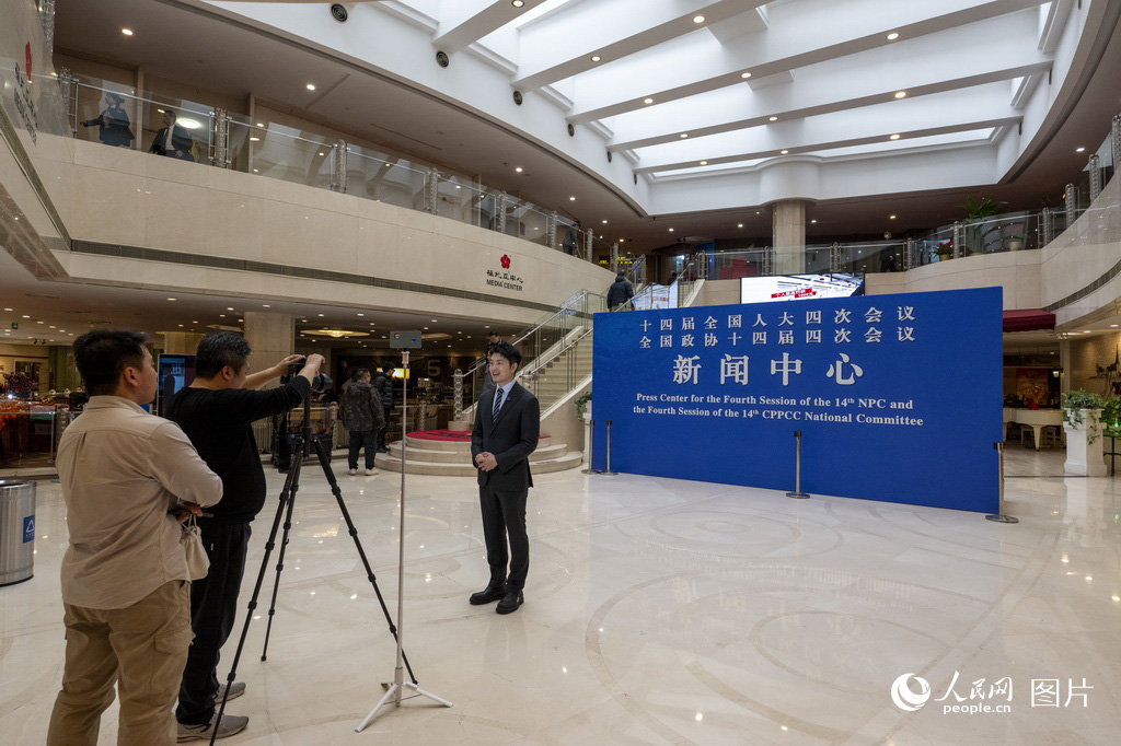 2月27日，媒体记者在全国两会新闻中心采访拍摄。人民网记者 翁奇羽摄