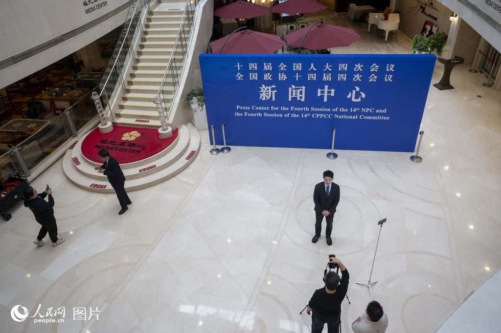 2月27日，媒体记者在全国两会新闻中心采访拍摄。人民网记者 翁奇羽摄