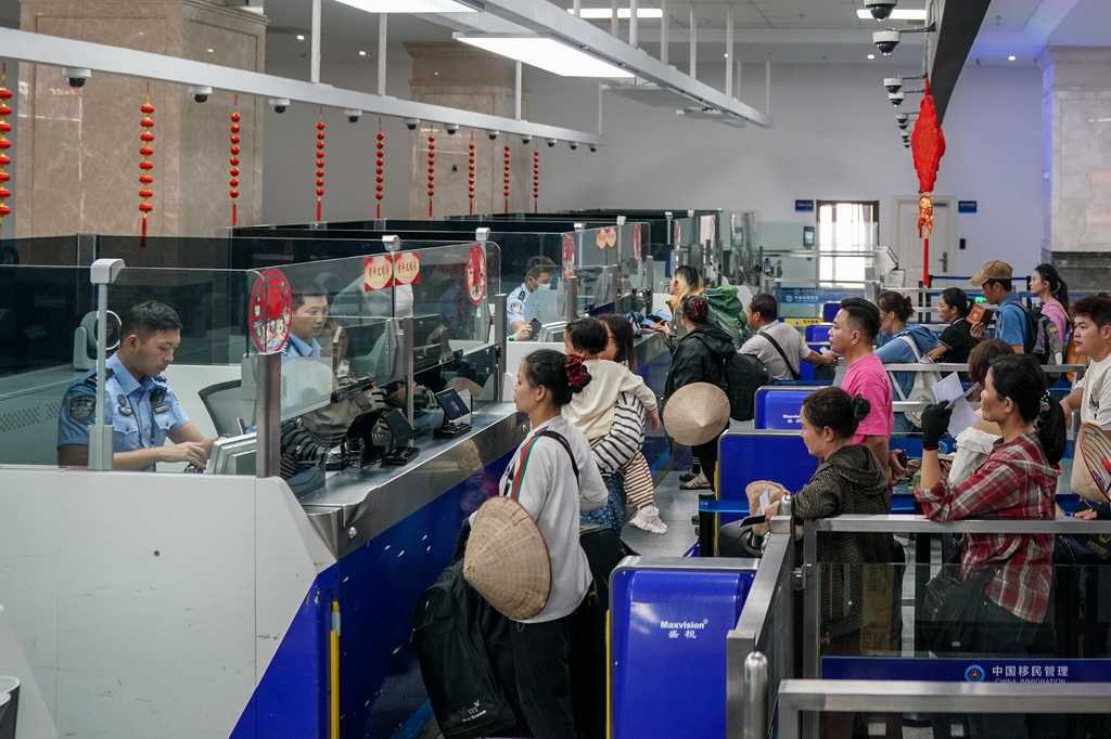 2月26日,河口边检站执勤民警为旅客办理边检手续。