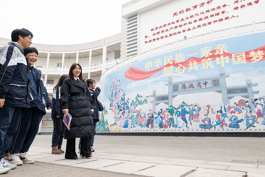 2月4日，在恩施土家族苗族自治州高级中学，张琼丽（右二）与学生从“中华民族一家亲 同心共筑中国梦”文化墙前走过。