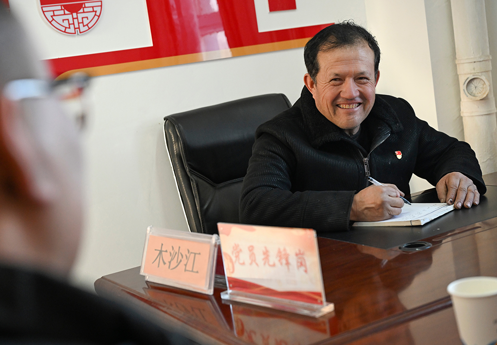 2月9日，在伊犁哈萨克自治州新源县，木沙江·海拉特在克热格塔斯村党群服务中心与来访的群众交流。新华社记者 王菲 摄