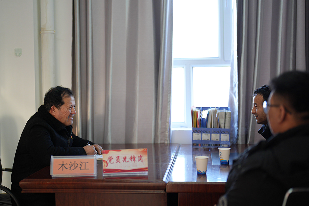2月9日,在伊犁哈萨克自治州新源县,木沙江·海拉特(左)在克热格塔斯村党群服务中心接待来访群众。新华社记者 辛悦卫 摄