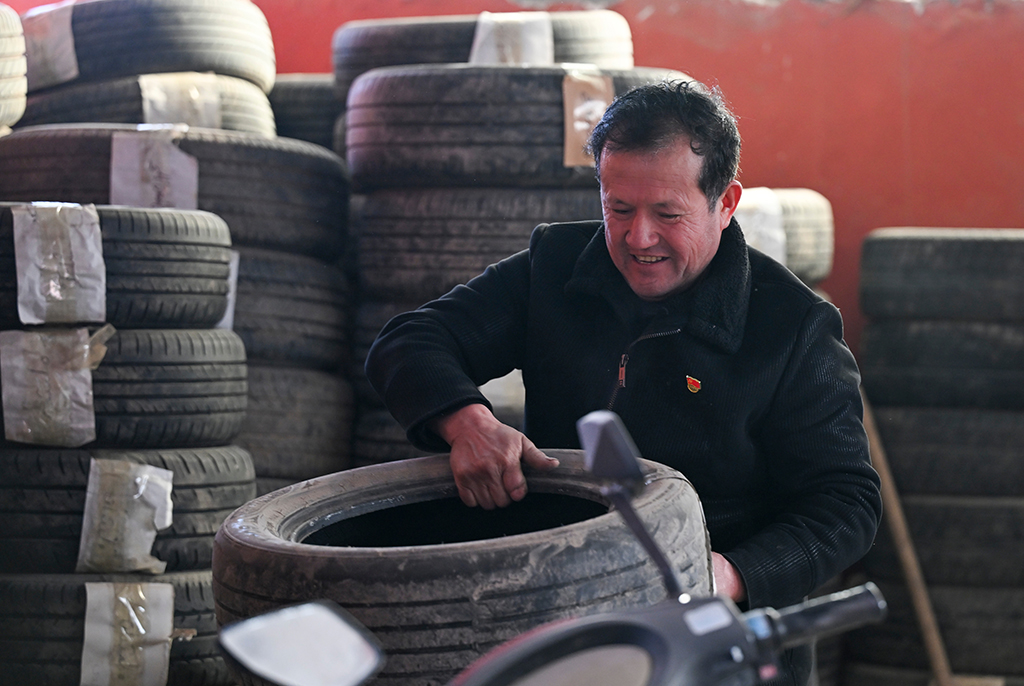 2月9日,在伊犁哈萨克自治州新源县克热格塔斯村,木沙江·海拉特在自己家中的工坊搬运轮胎。每年冬天,木沙江免费为周边村民提供存胎服务。
新华社记者 王菲 摄