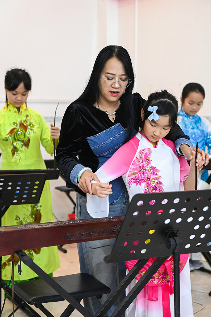 2月6日,在位于广西东兴市的工作室内,苏海珍指导学生弹奏独弦琴。