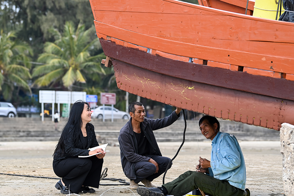 2月7日,在广西东兴市,苏海珍(左)与当地渔民交流,了解他们的期盼。