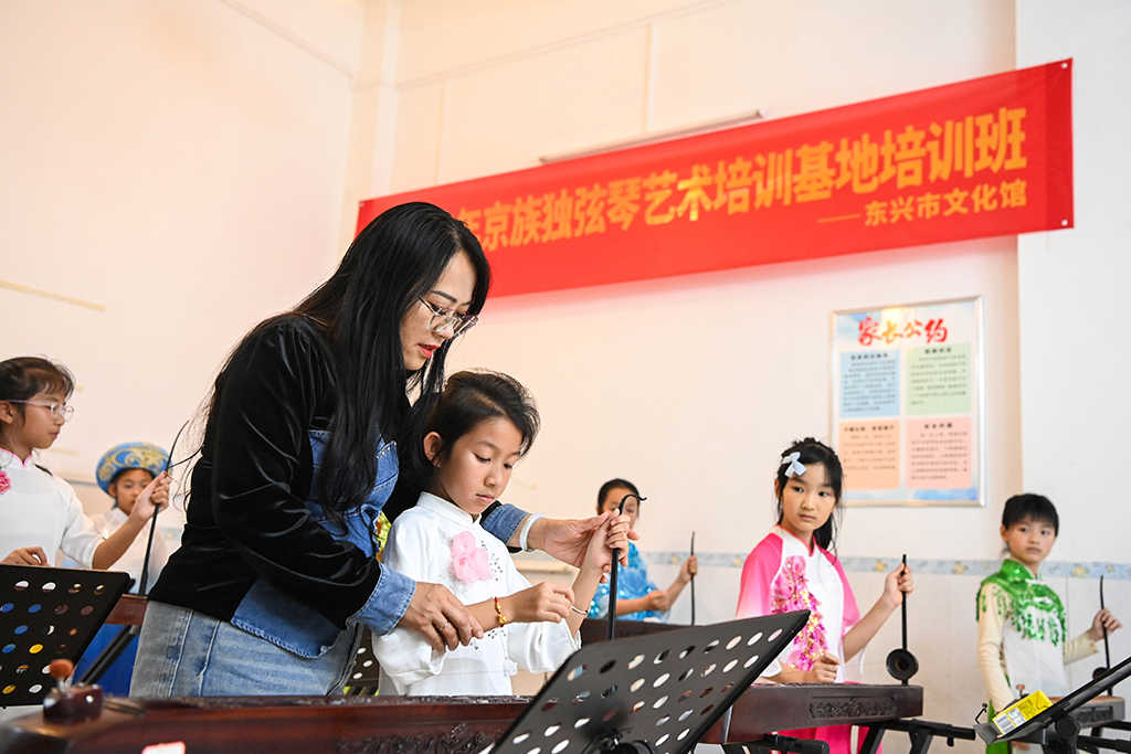 2月6日,在位于广西东兴市的工作室内,苏海珍指导学生弹奏独弦琴。