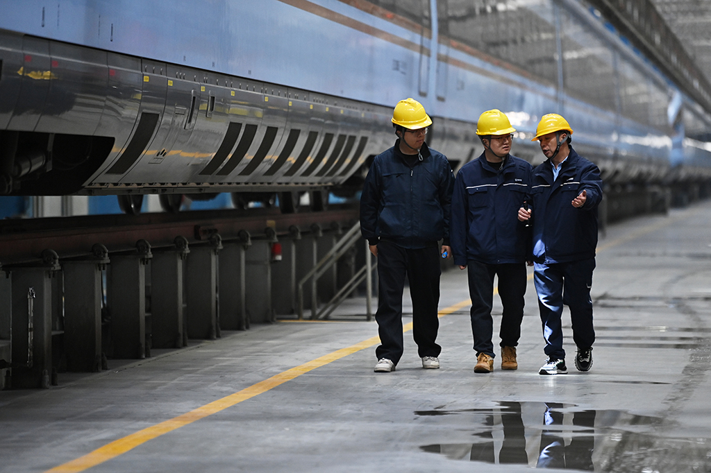  1月14日，在位于中国铁路西安局集团有限公司西安动车段的动车组检修库，董宏涛（右）和青年职工探讨业务。