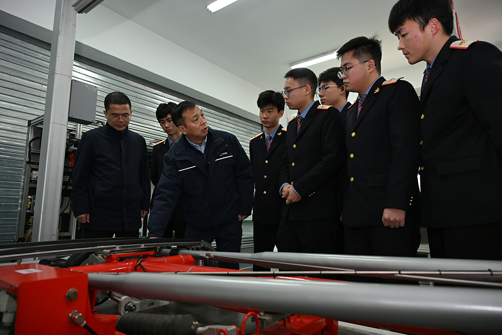  2月4日，在位于陕西省渭南市的陕西铁路工程职业技术学院实训室，董宏涛（左三）与师生交流。