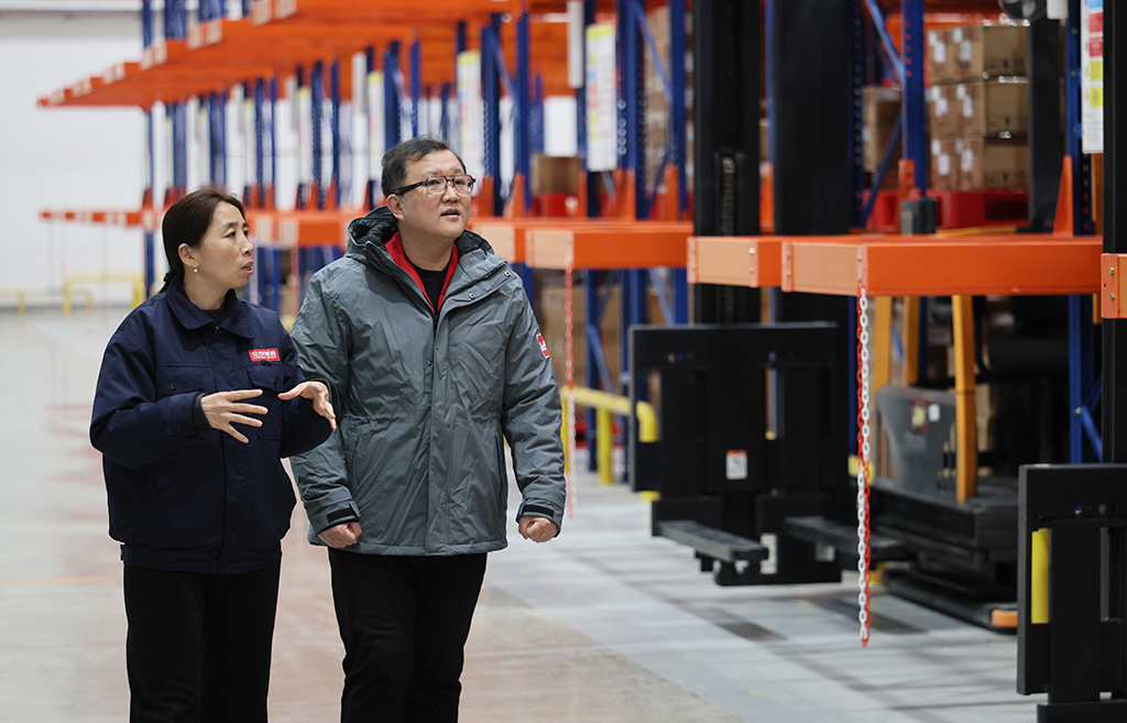 2月26日,在伍尔特(天津)电子有限公司,郭红静(左)调研智慧仓储运行情况。新华社记者 李然 摄
