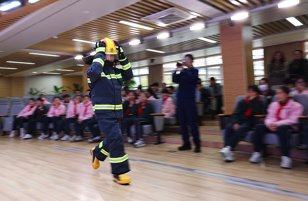 3月2日,上海市长宁区消防救援局为上海市天山初级中学学生带来一堂消防安全实训课。这是一名学生在体验穿着灭火防护服奔跑。新华社记者 方喆摄