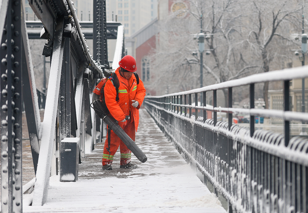 3月2日，环卫工人在天津市金汤桥上吹扫积雪。