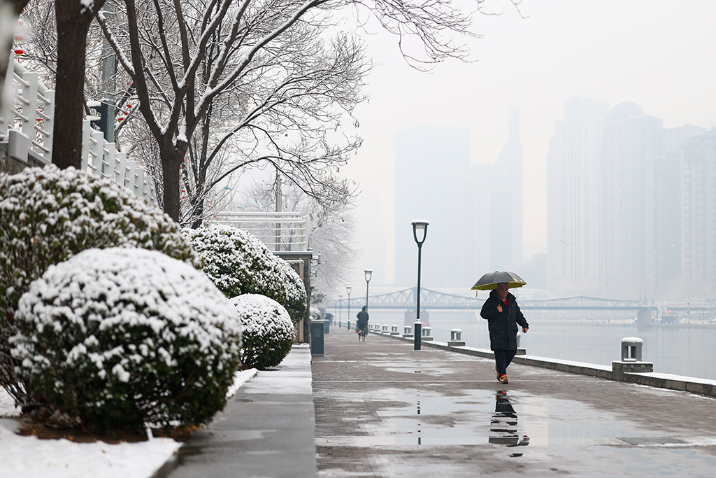 3月2日,市民雪中行走在天津海河亲水平台上。