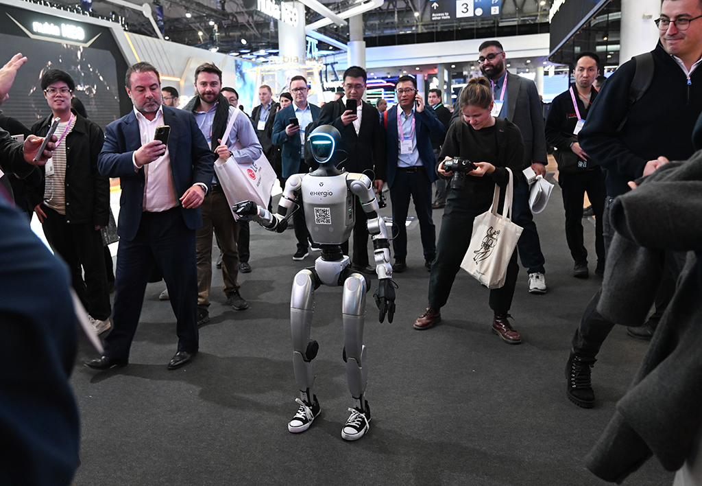 3月2日,在西班牙巴塞罗那,人们围观在展厅行走的人形机器人。