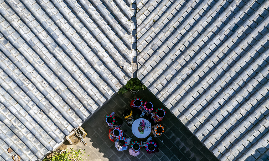 2月9日，金瑞瑞召集绣娘在自己的工作室内了解她们对彝绣产业发展的建议（无人机照片）。