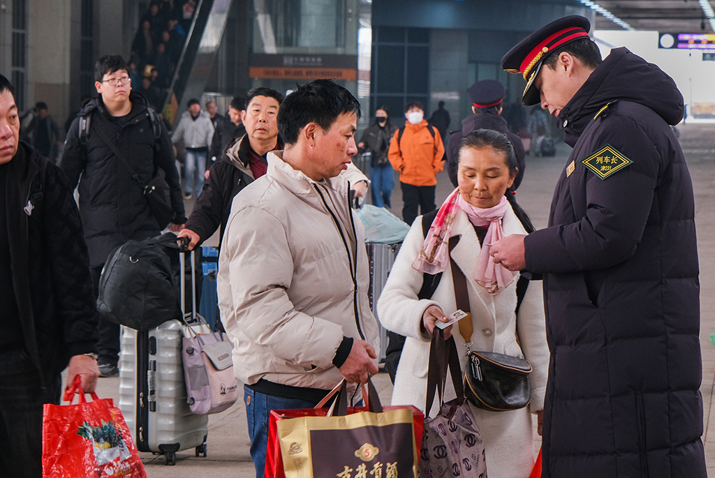 3月2日,T253次列车长在天津站站台解答旅客问询。