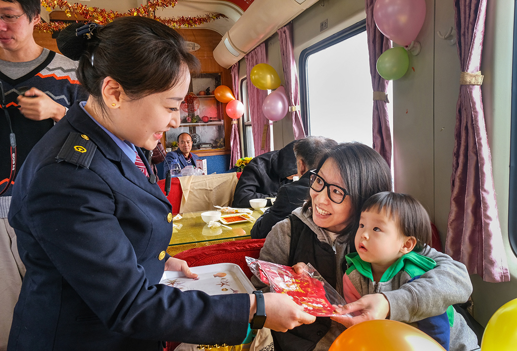 3月2日,T253次列车乘务人员为旅客送上节日纪念品。