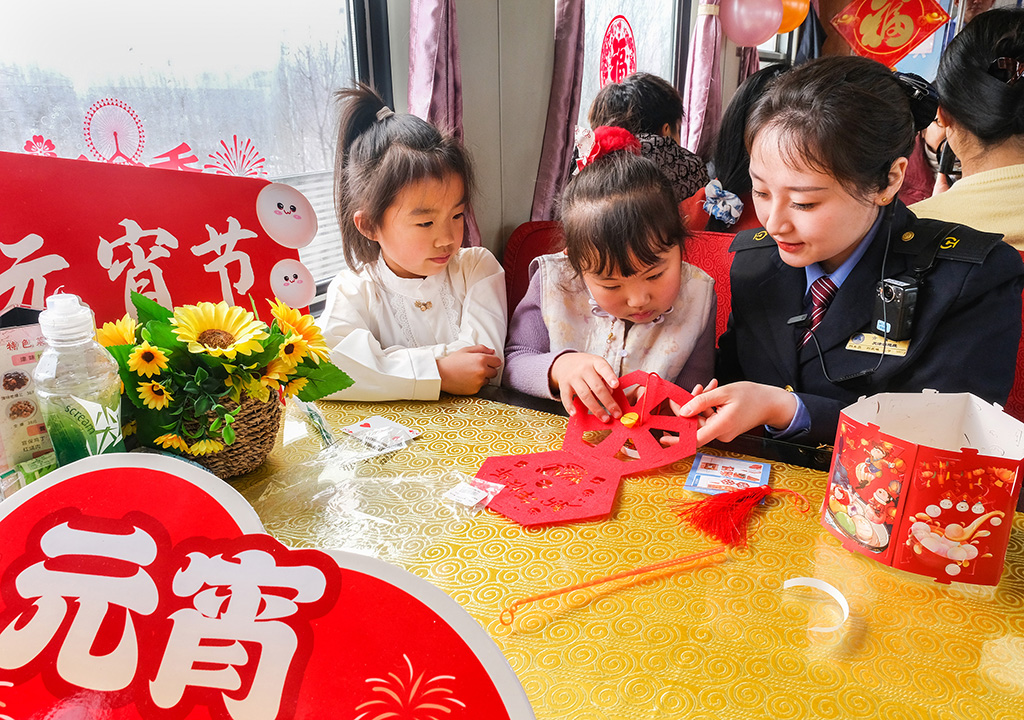 3月2日，T253次列车乘务人员与小旅客一起制作节日花灯。