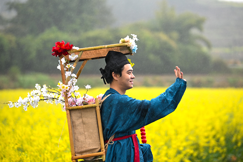 3月3日拍摄的油菜花田中的汉服爱好者。近日，重庆市永川区仙龙镇的万余亩油菜花竞相绽放，宛如一片金色海洋。