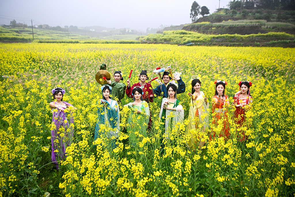 3月3日，汉服爱好者在油菜花田中合影。近日，重庆市永川区仙龙镇的万余亩油菜花竞相绽放，宛如一片金色海洋。