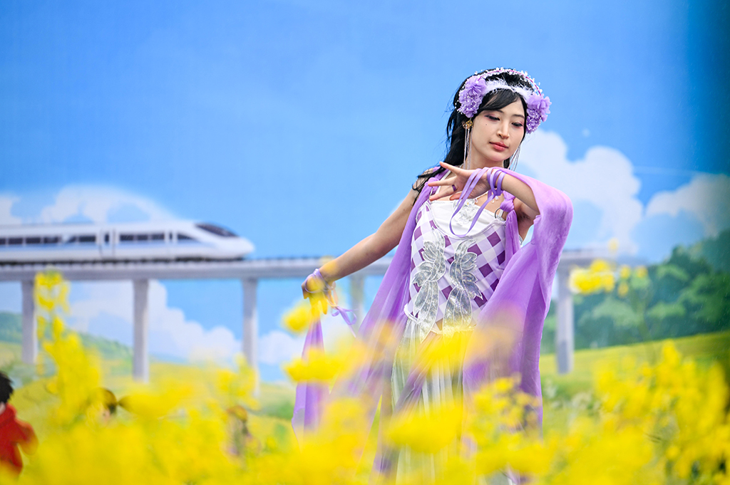 3月3日拍摄的油菜花田中的汉服爱好者。近日，重庆市永川区仙龙镇的万余亩油菜花竞相绽放，宛如一片金色海洋。