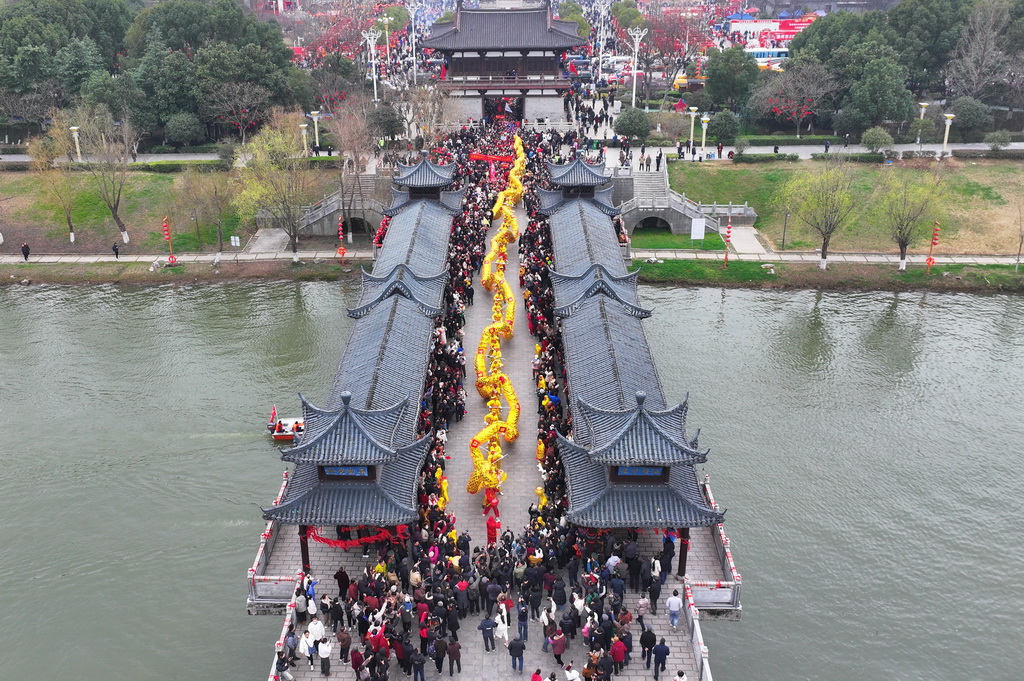 3月4日，民俗表演巡游队伍走过太平桥（无人机照片）。