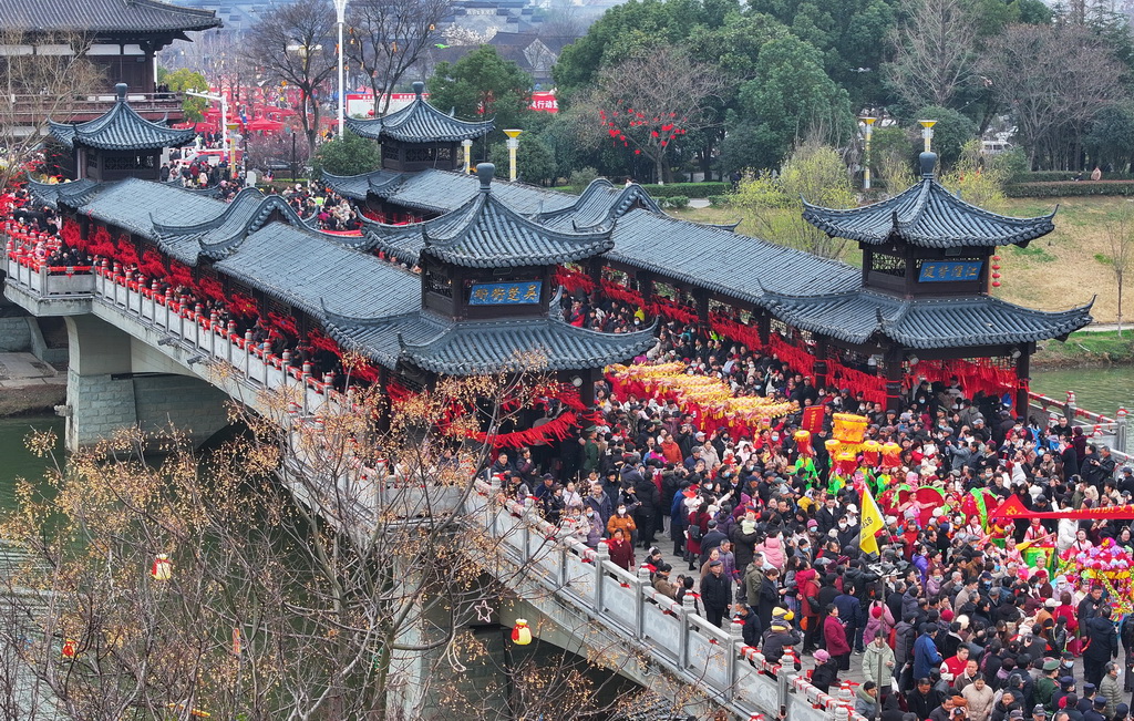 3月4日，民俗表演巡游队伍走过太平桥（无人机照片）。