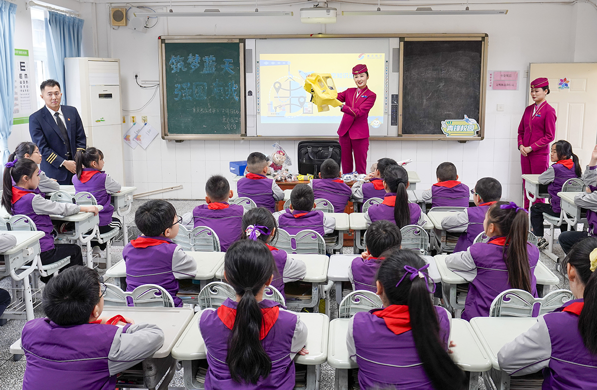 3月5日，在重庆市九龙坡区谢家湾朵力小学校的课堂上，来自重庆航空的空乘人员为学生们演示如何正确使用客机上的应急处置装备。