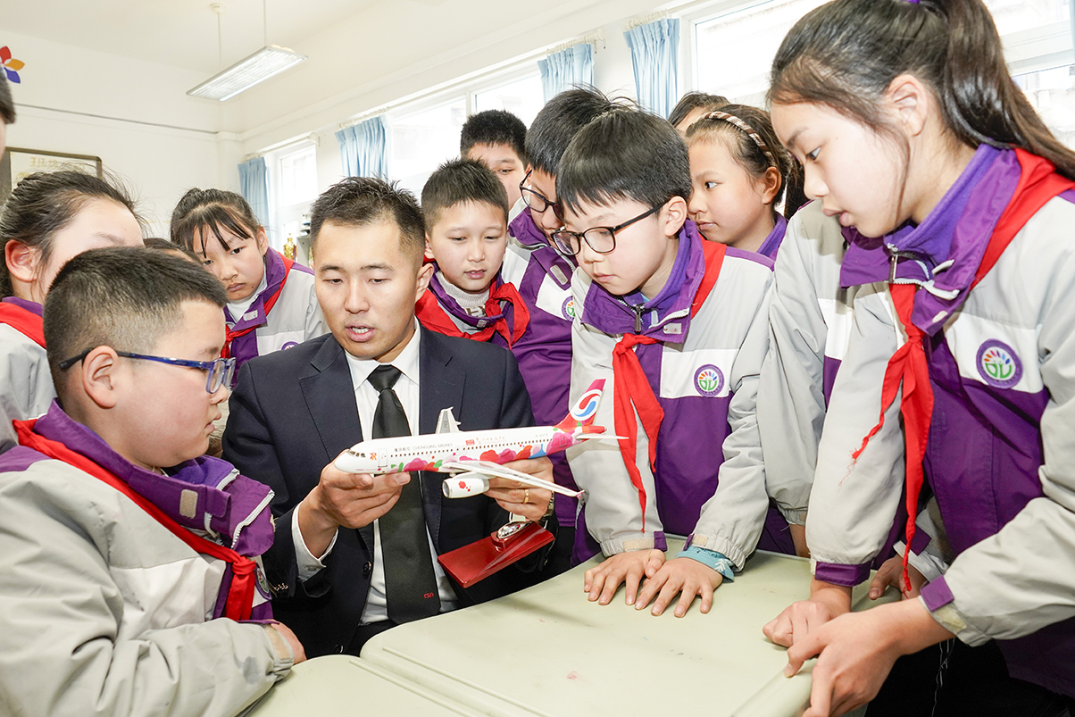 3月5日,在重庆市九龙坡区谢家湾朵力小学校的课堂上,来自重庆航空的飞行员李蒙邑用飞机模型向学生们讲解飞行原理。