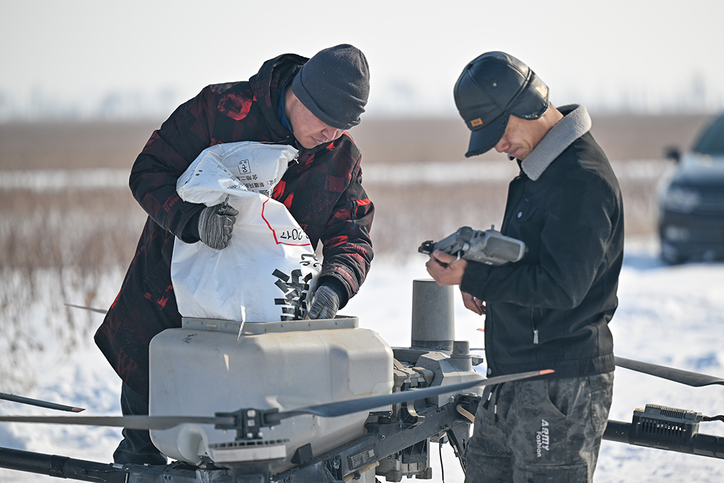 在新疆昌吉回族自治州玛纳斯县乐土驿镇，工作人员将播撒的返青肥料倒入无人机（3月4日摄）。